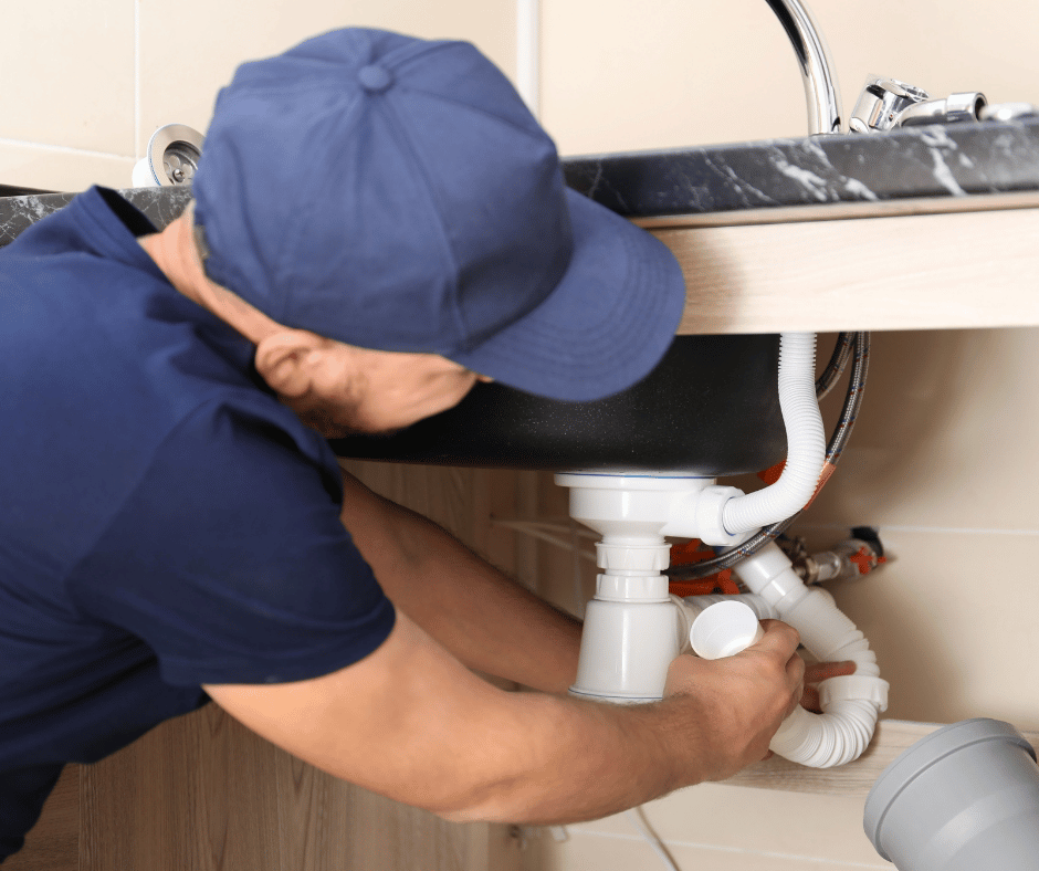 a professional plumber replacing sink trap in a home