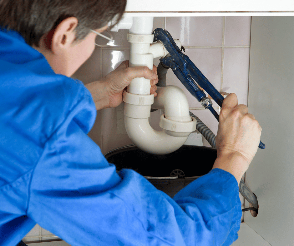 A plumber tightening a drain pipe in New Westminster, BC