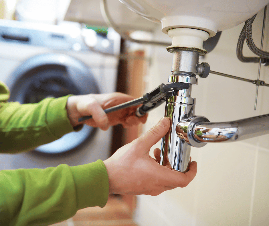A person attempting DIY plumbing repairs on a wash basin