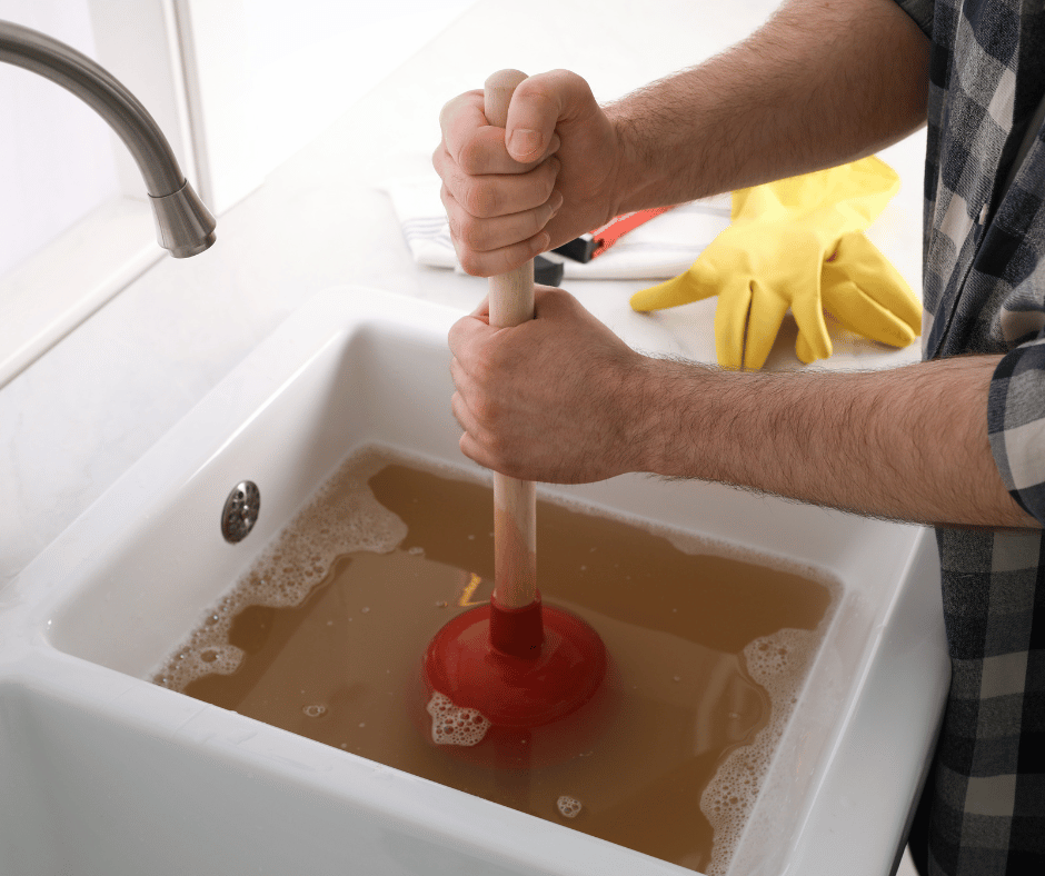 a man using a plunger on a clogged drain