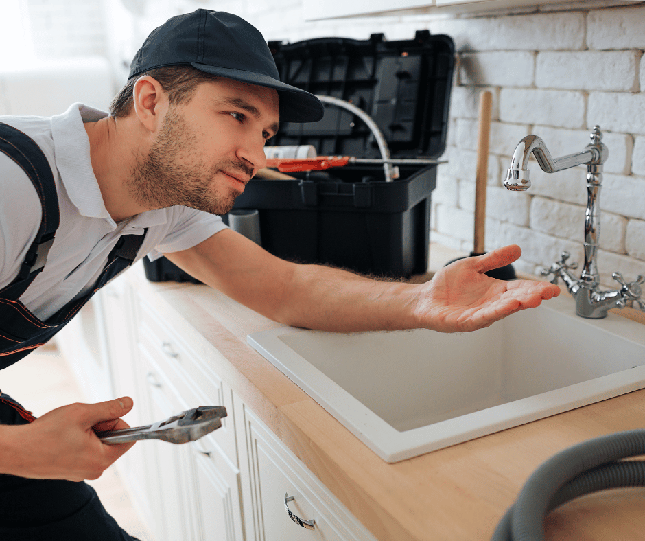 a young plumber in Surrey, BC, inspecting a faucet for leaks